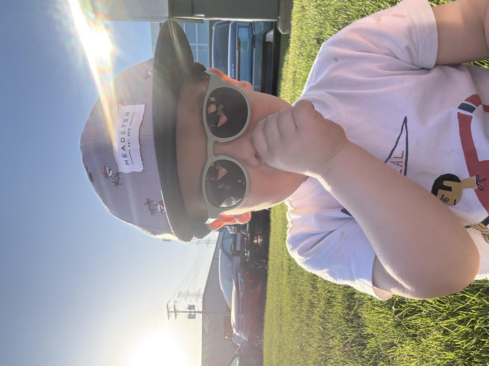 Lawrence’s youngest child wearing sunglasses and a sun hat